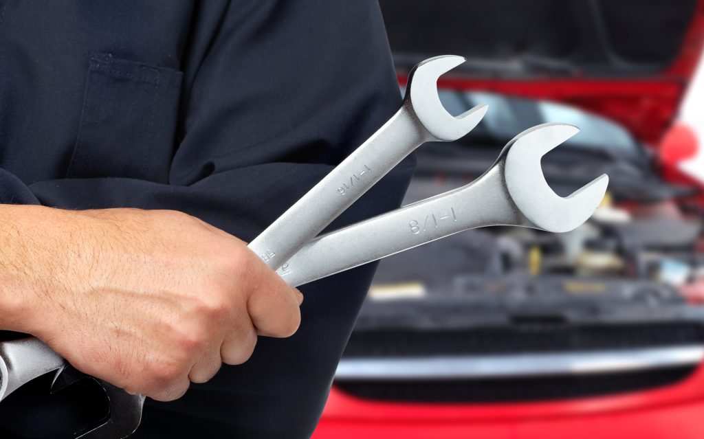 An INFINITI service technician holding two wrenches and ready to maintenance your luxury vehicle in Benton, AR 