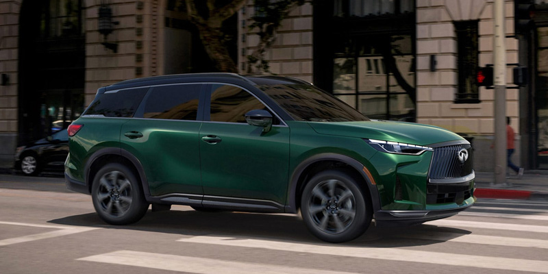 Green INFINITI SUV driving on city street