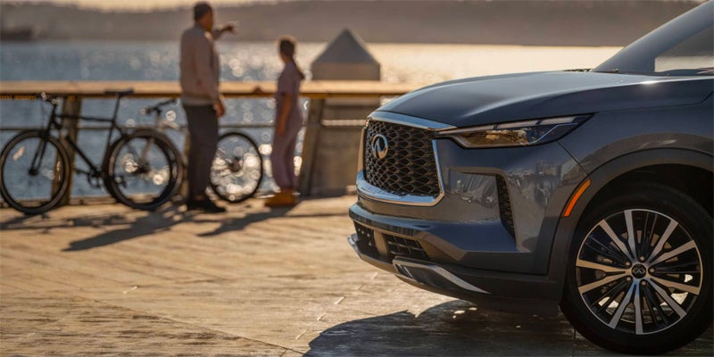 Gray Infiniti SUV parked near waterfront walkway