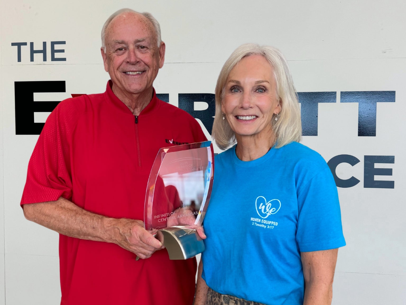 Dealership employee smiling in front of an Infiniti car